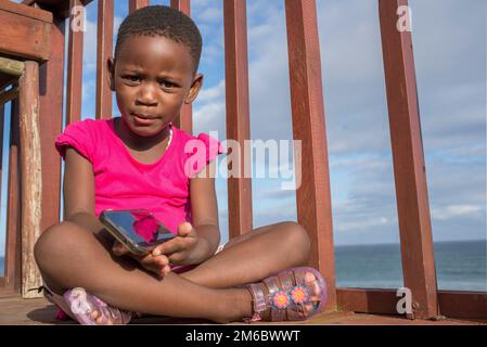 Petite fille sur le pont avec téléphone portable Banque D'Images