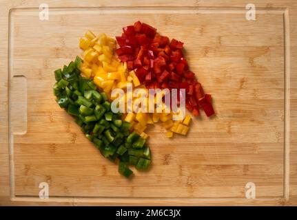 Fresh Cutted pièces paprika haut voir sur une planche à découper en bambou. Sans main. Banque D'Images