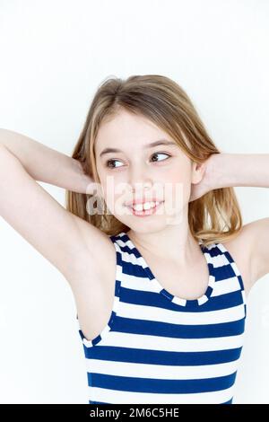 Jolie fille jouant avec des cheveux longs blonds debout Banque D'Images