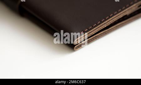 Photo macro des détails du portefeuille brun élégant pour hommes sur fond blanc. Accessoires en cuir pour hommes. Banque D'Images