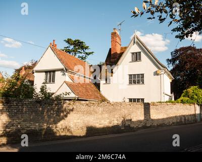 Une belle maison blanche de campagne dans la lumière douce et un mur de briques et une route à dedham Banque D'Images