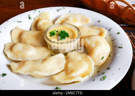 Plat vareniki russes et ukrainiennes avec une purée de pommes de terre et la crème fraîche et champignons sur plaque blanche. Close up. Banque D'Images