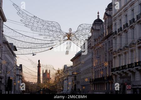 Spiritueux de Noël suspendus au-dessus de Regent Street St James. Waterloo place et chambres du Parlement derrière Londres, Angleterre. Banque D'Images