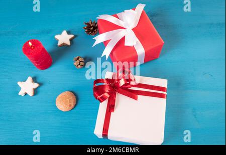 Cadeaux et bougie allumée sur la table en bois Banque D'Images