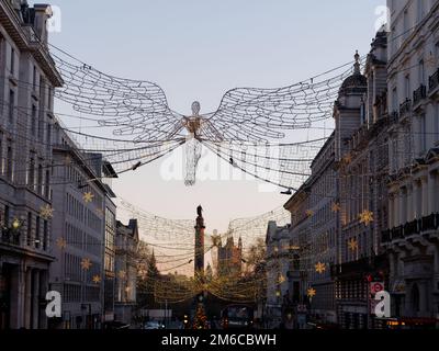 Spiritueux de Noël suspendus au-dessus de Regent Street St James. Waterloo place et chambres du Parlement derrière Londres, Angleterre. Banque D'Images