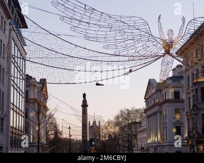 Spiritueux de Noël suspendus au-dessus de Regent Street St James. Waterloo place et chambres du Parlement derrière Londres, Angleterre. Banque D'Images