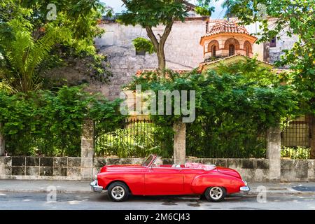 Voiture d'époque décapotable rouge américain garée sur le Malecon devant une forteresse el Morro à la Havane Cuba Banque D'Images