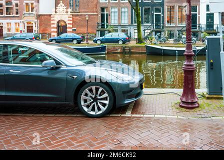 AMSTERDAM, PAYS-BAS, recharge de voiture électrique à une station de recharge sur la rue par un canal à Amsterdam Banque D'Images