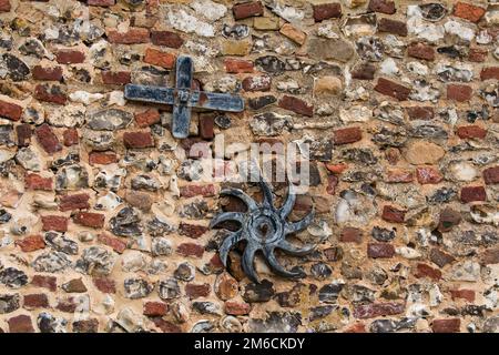 Les plaques d'ancrage fixé sur vieux mur en briques et silex. Banque D'Images