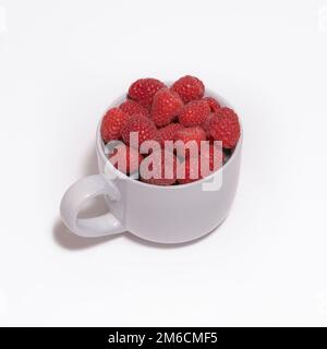 Baies de framboises dans un grand mug gris sur fond blanc. Format carré Banque D'Images