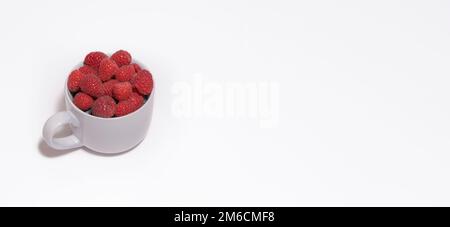 Baies de framboises dans un grand mug gris sur fond blanc. Carte Banque D'Images