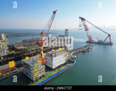 YANTAI, CHINE - le 3 JANVIER 2023 - Une grande grue flottante est utilisée pour déplacer la berge à la base de construction de CIMC Raffles à Yantai, en Chine orientale Banque D'Images