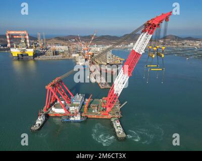 YANTAI, CHINE - le 3 JANVIER 2023 - Une grande grue flottante est utilisée pour déplacer la berge à la base de construction de CIMC Raffles à Yantai, en Chine orientale Banque D'Images