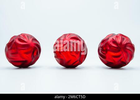 Boules de noël rouges en forme de fleur rose sur blanc. Banque D'Images