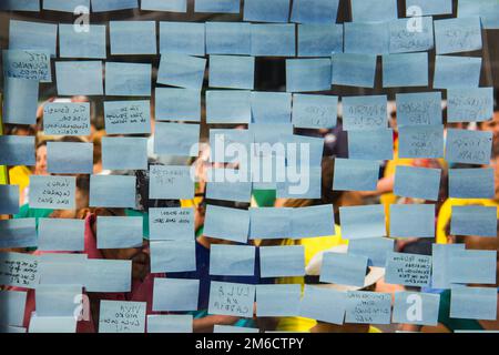 Post-it bleu sur un mur en verre. Banque D'Images