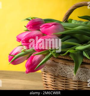 Beau bouquet de tulipes roses dans un panier en osier Banque D'Images