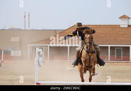 Le sergent d'état-major Juan Lopzes, Détachement de chevaux, quartier général régimentaire et troupe de quartier général, 11th Régiment de cavalerie blindée, balance son sabre à une cible alors que Commanche saute un obstacle sur le champ de parade du fort Concho, fort Concho, San Angelo, Texas, on 22 avril, 2022. Le concours sabre a évalué la capacité de Troopers à atteindre des objectifs à courte portée tout en se déplaçant rapidement. Banque D'Images