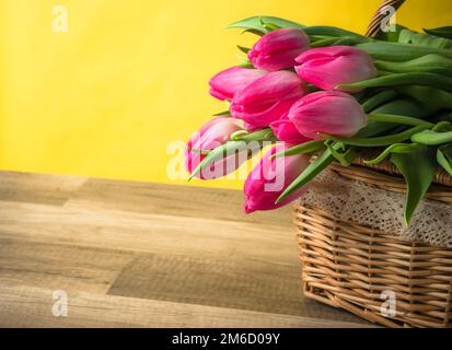 Beau bouquet de tulipes roses dans un panier en osier Banque D'Images