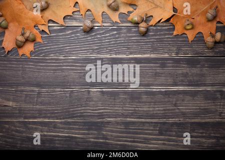 Feuilles de chêne d'automne et Acorns sur table en bois Banque D'Images