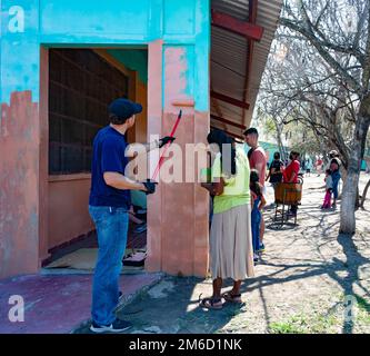 Les membres du service de la Force opérationnelle conjointe Bravo peignent une école pour les enfants lors d'un événement de sensibilisation communautaire à El Coquito, au Honduras, au 23 avril 2022. Plus de 20 bénévoles ont peint et aidé à travailler dans la cour dans la collectivité locale près de la base aérienne de Soto Cano, au Honduras. Banque D'Images