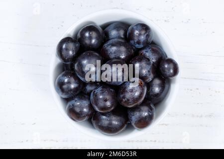 Raisins bleu fruits fruits fruits du dessus bol en bois de planche Banque D'Images