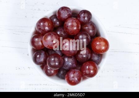 Raisins fruits rouges fruits du dessus bol en bois de planche Banque D'Images