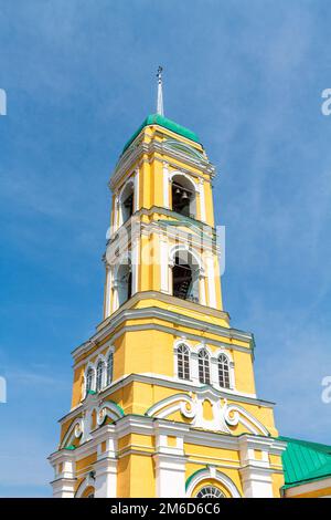 Église chrétienne orthodoxe jaune avec un dôme vert en été contre un ciel bleu avec des nuages blancs. Banque D'Images