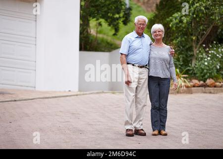 Dans mes bras pour seulement un moment, mais dans mon cœur pour toujours. un heureux couple senior debout à l'extérieur tout en souriant à la caméra. Banque D'Images