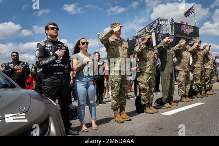 Le pilote de NASCAR, Erik Jones, le lieutenant-général Tony Bauernfeind, le vice-commandant du Commandement des opérations spéciales des États-Unis, et d'autres aviateurs se réunissent pour l'hymne national et le survol à Talladega Superspeedway 24 avril 2022, en Alabama. Le général a visité la course NASCAR où il a exécuté une cérémonie de jure-in pour 14 futurs aviateurs. Bauernfiend a également participé à des activités de pré-course, a roulé autour de la piste de 2,66 miles dans une voiture de course et a regardé la voiture #43 sponsorisée par l'Air Force de concourir et de diriger la course. (É.-U. Photo de la Force aérienne/Samuel King Jr.) Banque D'Images