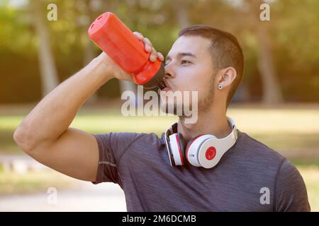 Eau potable coureur jeune homme courant jogging sports entraînement fitness Banque D'Images