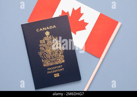 Un passeport canadien sur un drapeau canadien sur un fond bleu clair et solide Banque D'Images