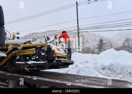 Hokkaido, Japon - 19 décembre 2022 : dans l'Hokkaido enneigé, l'ouvrier travaille encore dur Banque D'Images