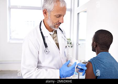 Mieux vaut prévenir que guérir. un homme mature médecin donnant à son patient une injection. Banque D'Images