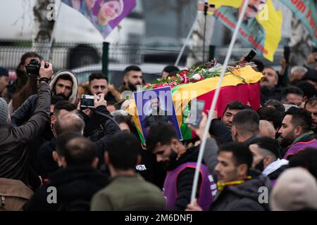 Villiers-le-Bel, Paris, 3 janvier 2023. Les membres de la communauté kurde pleurent dans les cercueils recouverts de fleurs, des trois victimes de coups de feu de la rue Enghien lors d'un service funéraire, dans la banlieue nord de Paris, Villiers-le-Bel, sur 3 janvier 2023. Trois personnes ont été tuées et trois blessées lors d'une fusillade dans la rue Enghien, dans le centre de Paris, à 23 décembre 2022, ont déclaré la police et les procureurs, ajoutant que le tireur avait été arrêté. Un Français de 69 ans a avoué une haine « pathologique » pour les étrangers, a déclaré le procureur de Paris Laure Beccuau sur 25 décembre 2022. Photo Banque D'Images