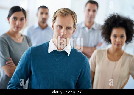 Étaient concentrés sur cent pour cent. Portrait d'un groupe de collègues divers se tenant dans un bureau. Banque D'Images