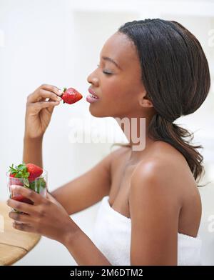 Commencer sa journée à la fraise. une jeune femme attrayante appréciant son matin de congé. Banque D'Images