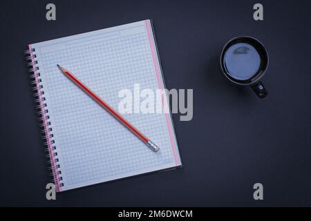 Nettoyer le crayon carré de classeur et une tasse de café sur fond noir concept de bureau Banque D'Images