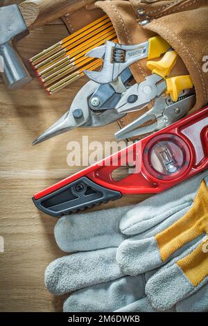 Composition de l'outillage de construction dans la ceinture à outils en cuir sur bois. Banque D'Images