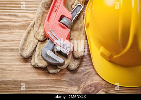 Casque de sécurité gants de protection en cuir clé à pipe sur bois concept de construction de planche. Banque D'Images