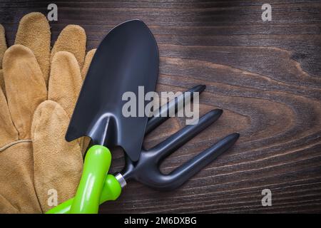 Gants de sécurité en cuir fourche à main et fourche à truelle sur le concept agricole de bois d'époque. Banque D'Images
