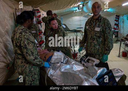 CAMP PENDLETON, Californie (25 avril 2022) - le personnel médical, affecté à l’établissement médical expéditionnaire (EMF) Juliet, traite un patient dans l’unité de soins intensifs lors de l’évaluation de l’état de préparation opérationnelle (ORE) de l’EMF Juliet. Le MINERAI a été mené à l'Institut de formation médicale expéditionnaire naval et évalue la capacité de traitement des patients, évalue la coordination entre les domaines fonctionnels et le travail d'équipe. Cette formation appuie le programme de préparation à plusieurs niveaux du chirurgien général et met en évidence la capacité de la médecine navale à générer et à maintenir des forces médicales prêtes à l’emploi. Banque D'Images