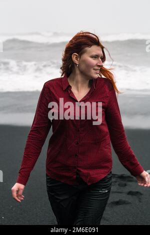 Femme attirante sur la plage noire de l'Islande photographie pittoresque Banque D'Images