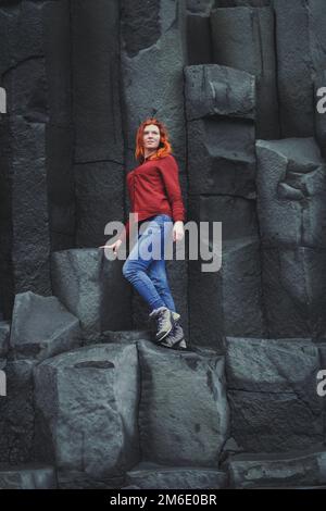 Femme souriante debout sur des falaises de basalte photographie pittoresque Banque D'Images