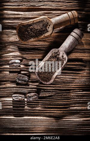 Grains de café moulus dans une cuillère sur un panneau en bois d'époque. Banque D'Images