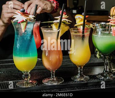 Cocktails boissons au bar. Bar-salon avec boissons alcoolisées sur la table du bar, boissons de fête colorées. Banque D'Images