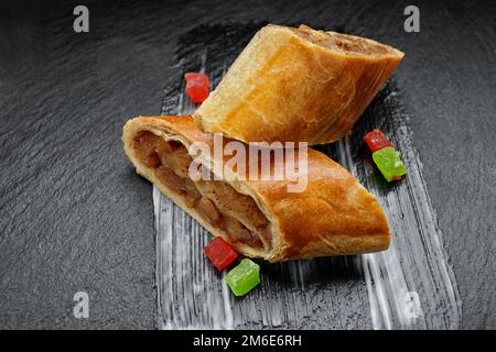 Strudel viennoise cuit avec une pomme, sur une pierre noire Banque D'Images