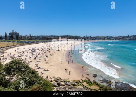 Été 2023, Bondi Beach Sydney sur un ciel bleu clair jour d'été, plage pleine et bondée avec les gens de bains de soleil et de natation, Sydney, NSW, Australie Banque D'Images