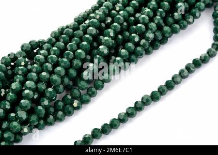 Perles isolantes en cristal de verre vert brillant sur fond blanc. À utiliser pour les bijoux à perles de bricolage Banque D'Images