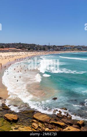 Été 2023, Bondi Beach Sydney sur un ciel bleu clair jour d'été, plage pleine et bondée avec les gens de bains de soleil et de natation, Sydney, NSW, Australie Banque D'Images