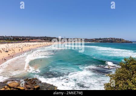 Été 2023, Bondi Beach Sydney sur un ciel bleu clair jour d'été, plage pleine et bondée avec les gens de bains de soleil et de natation, Sydney, NSW, Australie Banque D'Images